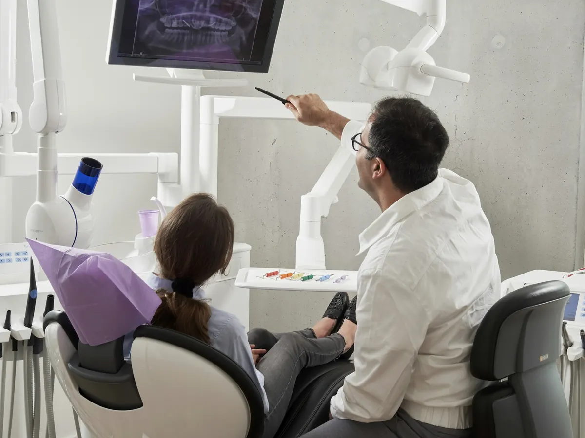 Dentist reviewing an X-ray with a patient in the chair